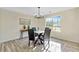 Dining room with natural light, modern chandelier, and a glass-top table with four chairs at 482 Chase Marion Way, Mcdonough, GA 30253