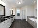 Double vanity bathroom with dark countertops and soaking tub at 3394 Bryerstone Se Cir, Smyrna, GA 30080