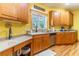 Bright kitchen featuring wood cabinets, double sink, and hardwood floors at 427 Chadwick Pl, Canton, GA 30114