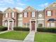 Brick townhome with 2-story elevation, landscaped lawn, and a charming front porch at 7512 Rutgers Cir, Fairburn, GA 30213