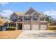 Brick two-story house with three-car garage and landscaped yard at 7691 Brazos Trl, Fairburn, GA 30213