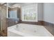 Relax in this bathroom's luxurious jetted tub and walk-in shower at 2114 Summit Ct, Loganville, GA 30052