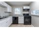 Modern kitchen with white cabinets, black appliances, and granite countertops at 2196 Swallow Se Cir, Atlanta, GA 30315