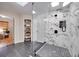 Large walk-in shower with marble tile and pebble floor at 923 Pine Cir, Woodstock, GA 30189