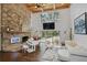 Open living area with stone fireplace, large windows, and a grand piano at 2440 Emerald Dr, Jonesboro, GA 30236