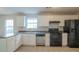 Kitchen with white cabinets, black appliances, and tile floor at 6390 Alford Cir, Lithonia, GA 30058