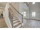 Elegant staircase with wrought iron balusters and wooden handrail at 203 Arabella Pkwy, Locust Grove, GA 30248