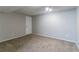 Large carpeted basement room with neutral walls and a door at 2076 Scarbrough Dr, Stone Mountain, GA 30088