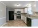Galley-style kitchen with white cabinets, stainless steel appliances and granite countertops at 2076 Scarbrough Dr, Stone Mountain, GA 30088