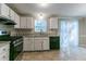 Kitchen with white cabinets, stainless steel appliances and a view to a backyard at 2076 Scarbrough Dr, Stone Mountain, GA 30088