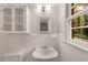 Clean bathroom with pedestal sink and glass-front cabinet at 4800 Kenilworth Dr, Stone Mountain, GA 30083