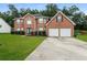 Brick house with two-car garage and landscaped lawn at 6899 Dalehollow Dr, Lithonia, GA 30058