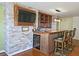 Basement bar with stone feature wall, wine rack, and seating at 4560 Lake Hill Trl, Ellenwood, GA 30294