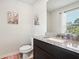 Half bathroom with granite countertop, dark wood vanity, and decorative rug at 1363 Midnight Ride Ct, Hampton, GA 30228