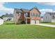 Brick two-story house with a two car garage and landscaped lawn at 1363 Midnight Ride Ct, Hampton, GA 30228