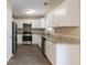 Renovated kitchen with white cabinets, granite countertops, and stainless steel appliances at 5382 Kemper Pl, Stone Mountain, GA 30088