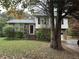 Brick and white sided two-story house with a grassy yard and trees at 110 Belmont Farms Dr, Ellenwood, GA 30294