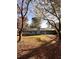 View of the home's backyard with mature trees and patio at 2815 Highway 20 Se, Conyers, GA 30013