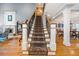 Elegant staircase with wrought iron railing and hardwood flooring at 8170 Hurakan Creek Xing, Cumming, GA 30028