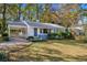 Front view of a cozy white house with a covered porch and landscaped yard at 2627 Elsinore St, East Point, GA 30344