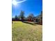 Sunny backyard with grassy area, wooden fence, and trampoline at 408 Othello Dr, Hampton, GA 30228