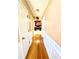 Long hallway with wood floors and white wainscoting leading to the kitchen at 408 Othello Dr, Hampton, GA 30228