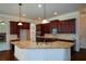 Spacious kitchen with granite island, dark wood cabinets, and hardwood floors at 168 Waypoint Dr, Stockbridge, GA 30281