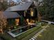 Modern home with black exterior, long water feature, and stone pathway at night at 2716 Ridgewood Nw Rd, Atlanta, GA 30327