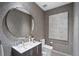 Modern powder room with patterned wall and round mirror at 2716 Ridgewood Nw Rd, Atlanta, GA 30327