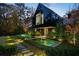 Modern home with black exterior, long water feature, and stone pathway at night at 2716 Ridgewood Nw Rd, Atlanta, GA 30327