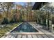 Modern rectangular pool with stone patio and wooded backdrop at 2716 Ridgewood Nw Rd, Atlanta, GA 30327