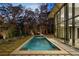 Modern rectangular pool with stone patio and wooded backdrop at 2716 Ridgewood Nw Rd, Atlanta, GA 30327