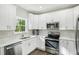 Modern kitchen with white shaker cabinets and stainless steel appliances at 4597 Dahlia Dr, Pine Lake, GA 30072