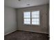 Small bedroom with gray walls and dark brown carpet at 4922 Rock Springs Rd, Lithonia, GA 30038