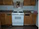 White stove and wood cabinets in a simple kitchen at 4922 Rock Springs Rd, Lithonia, GA 30038