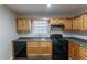 Galley kitchen with wood cabinets, black appliances, and dark countertops at 223 Clydesdale Se Ln, Mableton, GA 30126