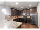 Modern kitchen with dark cabinetry, granite countertops, and stainless steel appliances at 318 Emporia Loop, Mcdonough, GA 30253