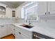 Kitchen features white cabinets, quartz countertops, and a farmhouse sink at 1112 Osprey Nw Rdg, Kennesaw, GA 30152