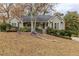 Tan house with gray roof, front porch, and landscaping; situated on a sloping lawn at 271 Kings Walk, Douglasville, GA 30134