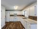 White kitchen with wood-look flooring, white cabinets, and stainless steel appliances at 271 Kings Walk, Douglasville, GA 30134