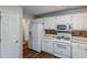 White kitchen with wood-look flooring, white cabinets and appliances at 271 Kings Walk, Douglasville, GA 30134