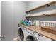 Laundry room features washer, dryer, and custom wood shelving at 1222 Poston Se Pl, Smyrna, GA 30080