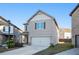 Two-story house with beige siding, attached garage, and a landscaped front yard at 2291 Elise Way, Hampton, GA 30228