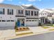 Two-story townhome with white and gray brick exterior, two-car garage, and landscaped front yard at 510 Cooper Ln, Woodstock, GA 30189