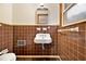 Brown tiled bathroom with sink, toilet, and small window at 2052 Brannen Se Rd, Atlanta, GA 30316