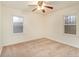 Empty bedroom with ceiling fan, carpeted floor, and two windows at 2052 Brannen Se Rd, Atlanta, GA 30316