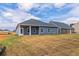 Back of house with covered patio and grassy backyard at 231 Orwell Dr, Social Circle, GA 30025