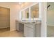 Double vanity bathroom with granite countertop and lighted mirrors at 231 Orwell Dr, Social Circle, GA 30025