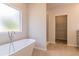 Relaxing bathroom with soaking tub, walk-in shower, and spacious closet at 231 Orwell Dr, Social Circle, GA 30025