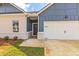 Front entrance with gray door and white-framed windows, next to a two-car garage at 231 Orwell Dr, Social Circle, GA 30025